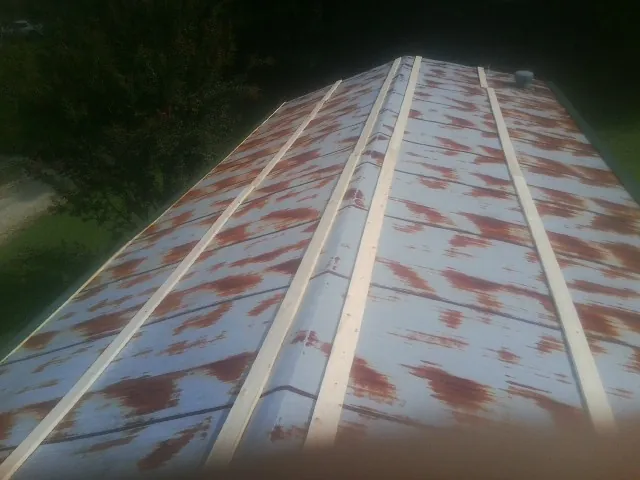 Rusted metal roof panels with new wood purlins before replacement — Storm Damage Roof Repair in Itasca by Roofing Brothers