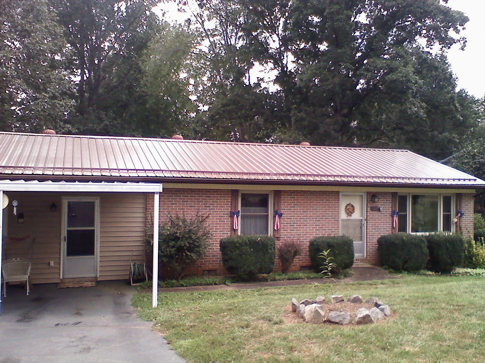 Bronze metal roof and carport on a brick ranch home — Roof Repair work by our crew in Itasca